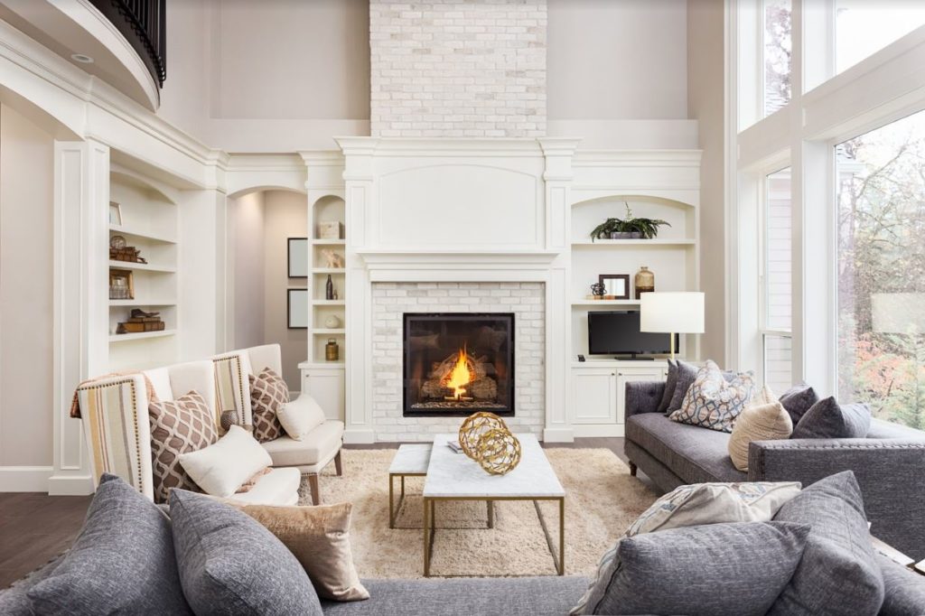 White fireplace in a large, luxurious living room.