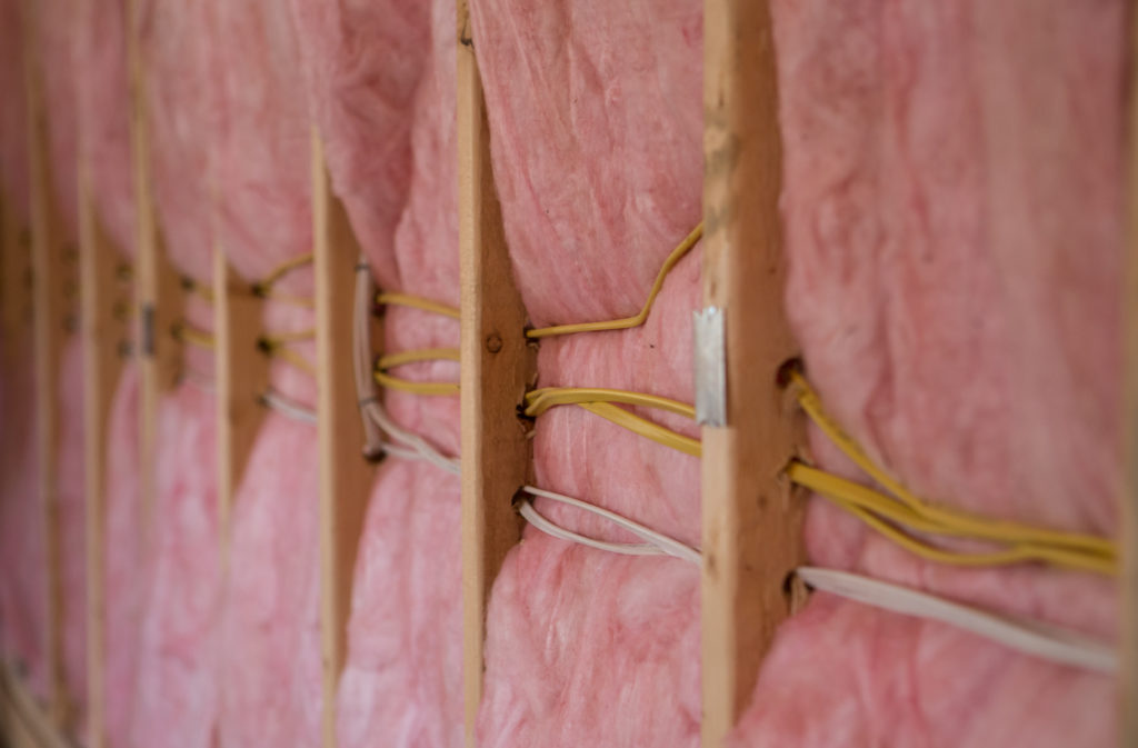 Pink fiberglass batt insulation in a wall.